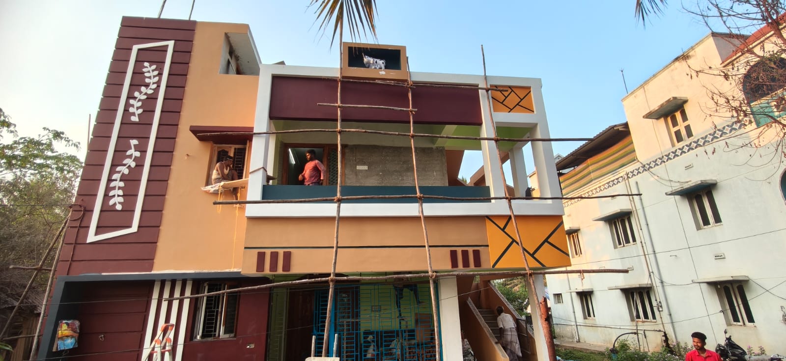 Completed G+2 residential home with bold maroon decorative panel and white leaf motif facade, Mannarkudi